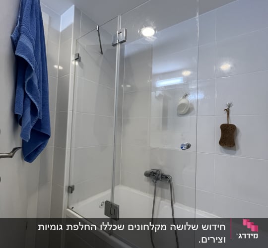 מקלחת עם דלת זכוכית, מגבת כחולה תלויה